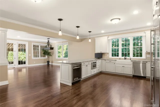 a large kitchen with sink hardwood floor and stainless steel appliances