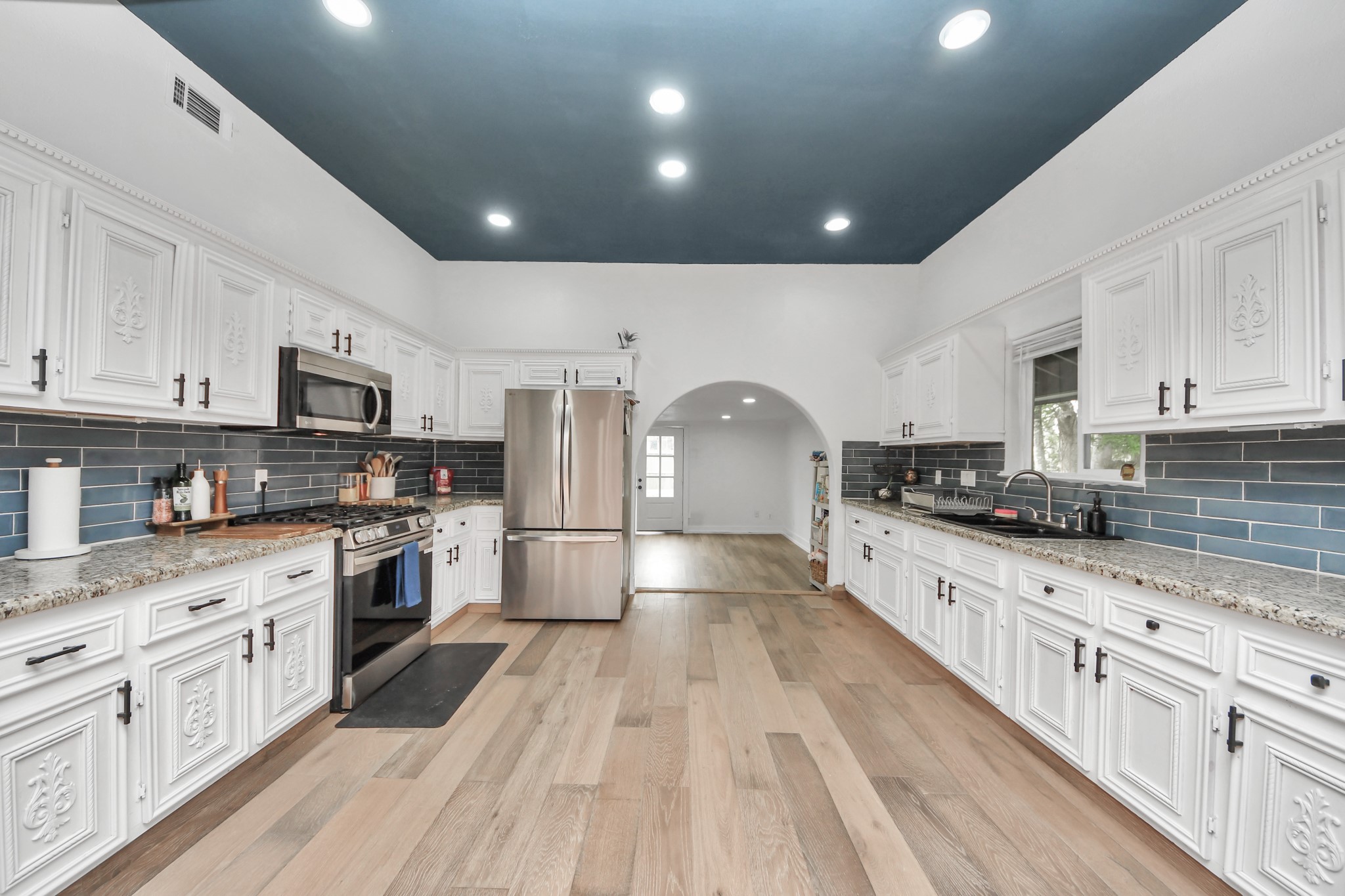 6833 Stonehaven Way Houston, TX 77085 - Photo 6 of 23 a large kitchen with cabinets stainless steel appliances lots of counter space and wooden floor