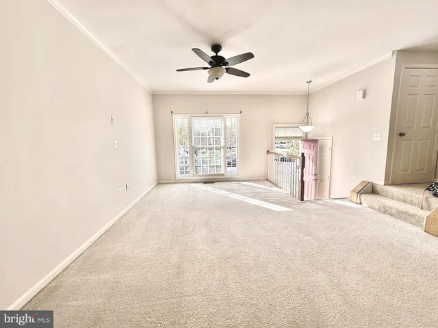 a view of a livingroom with a ceiling fan and window