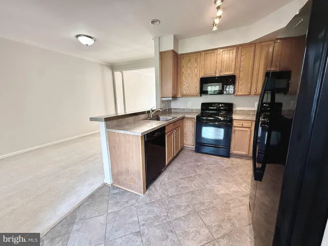 a kitchen with stainless steel appliances granite countertop a refrigerator a stove top oven a sink and dishwasher