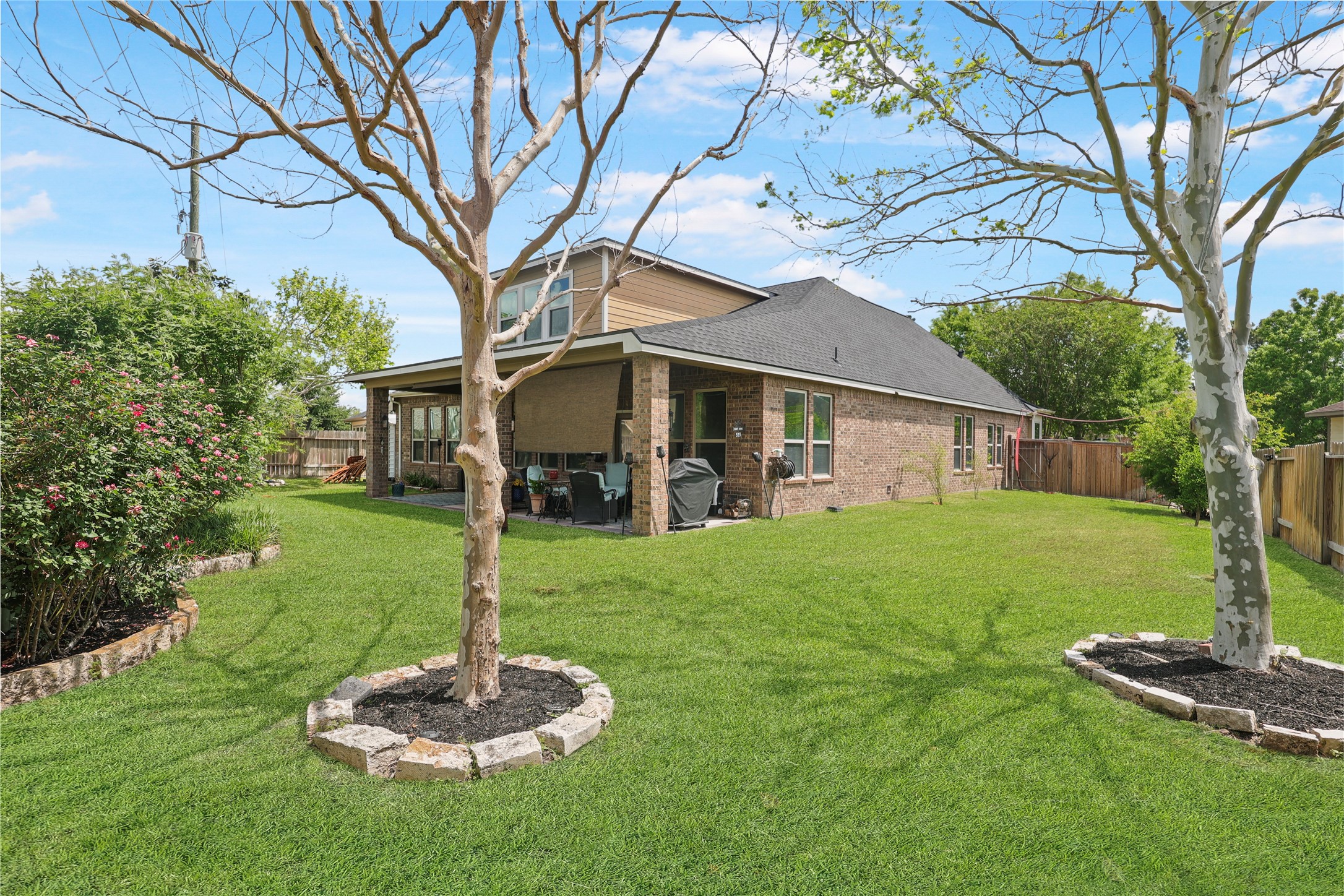 31311 Brighton Brook Lane Spring, TX 77386 - Photo 33 of 43 Relax or entertain in the expansive backyard featuring lush greenery and a covered deck.