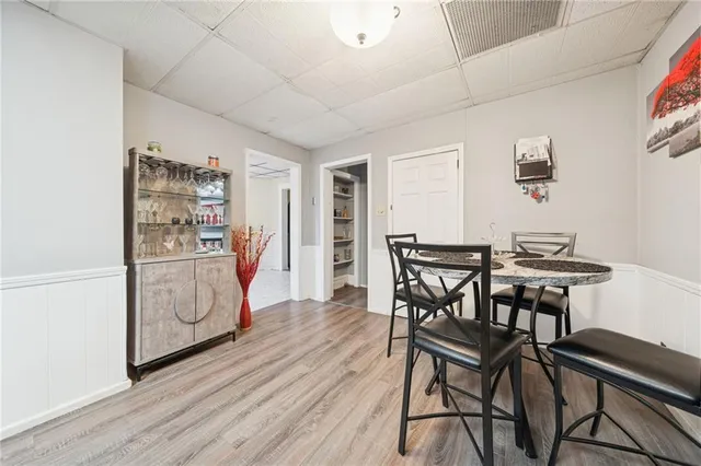 a kitchen with stainless steel appliances kitchen island granite countertop a table chairs in it and wooden floors