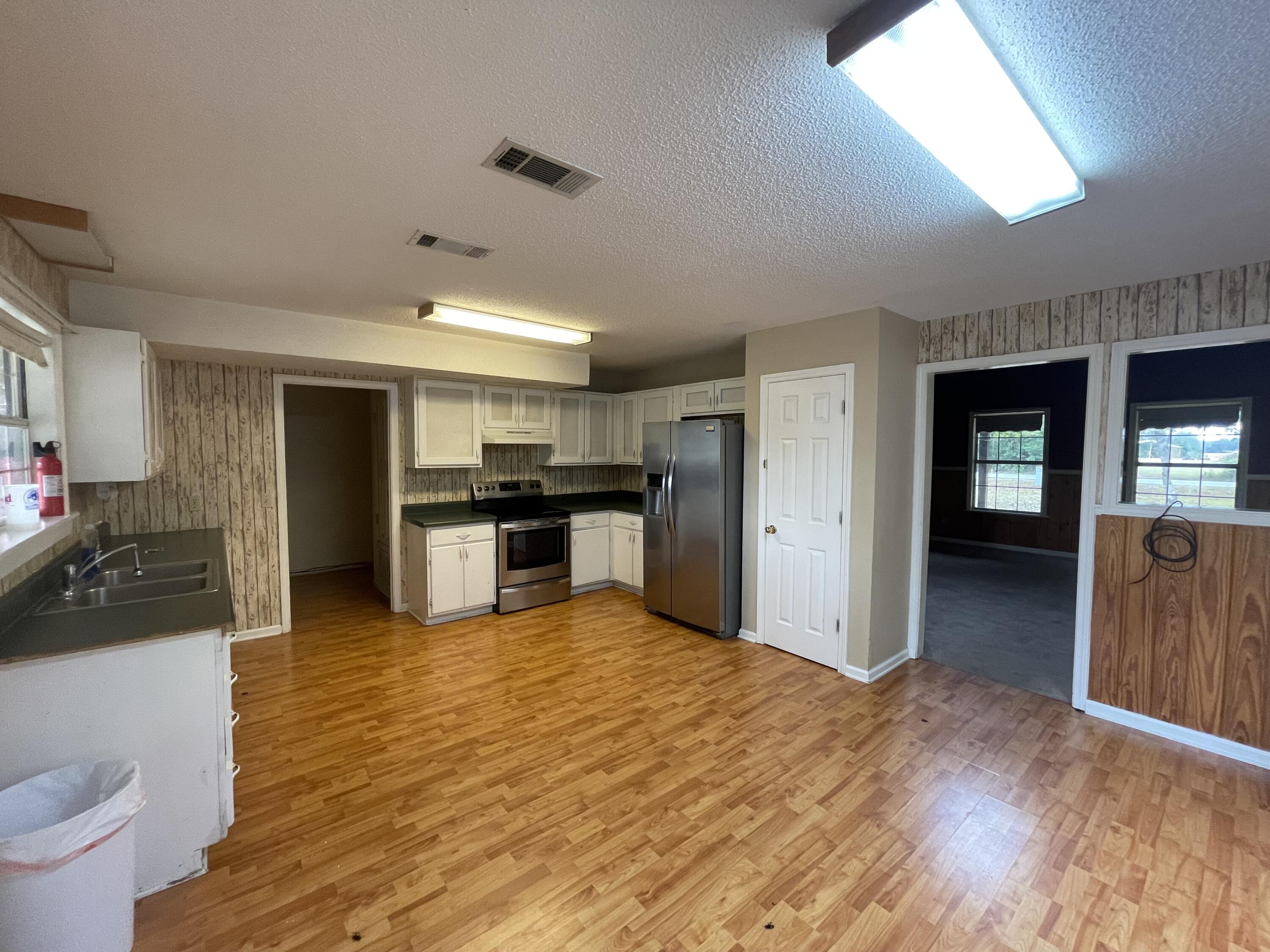 5341 Galiver Cutoff Baker, FL 32531 - Photo 3 of 13 a kitchen with stainless steel appliances kitchen island granite countertop a refrigerator and a sink