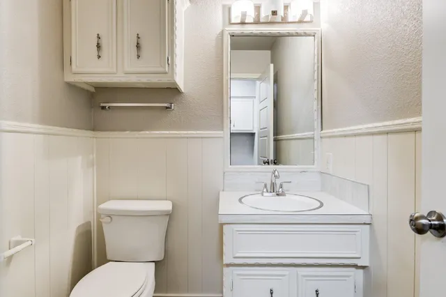 a bathroom with a toilet sink and mirror