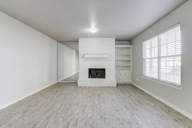 an empty room with a fireplace and window