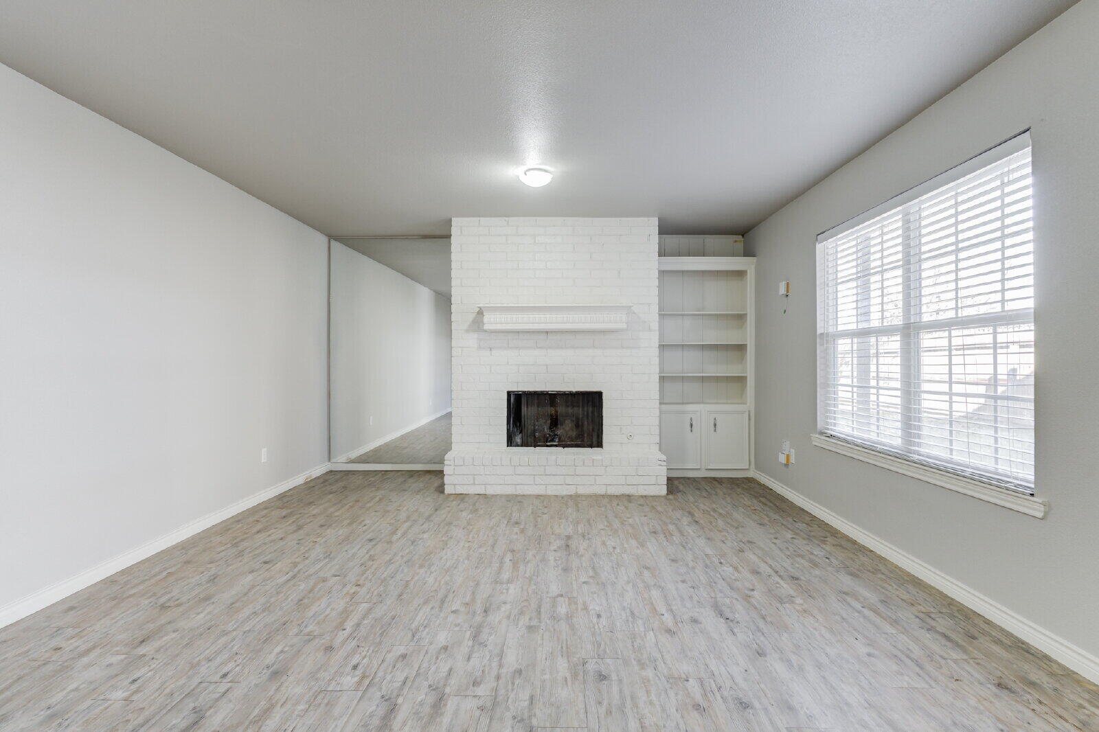 4320 52nd Street, Unit B Lubbock, TX 79413 - Photo 4 of 25 an empty room with a fireplace and window