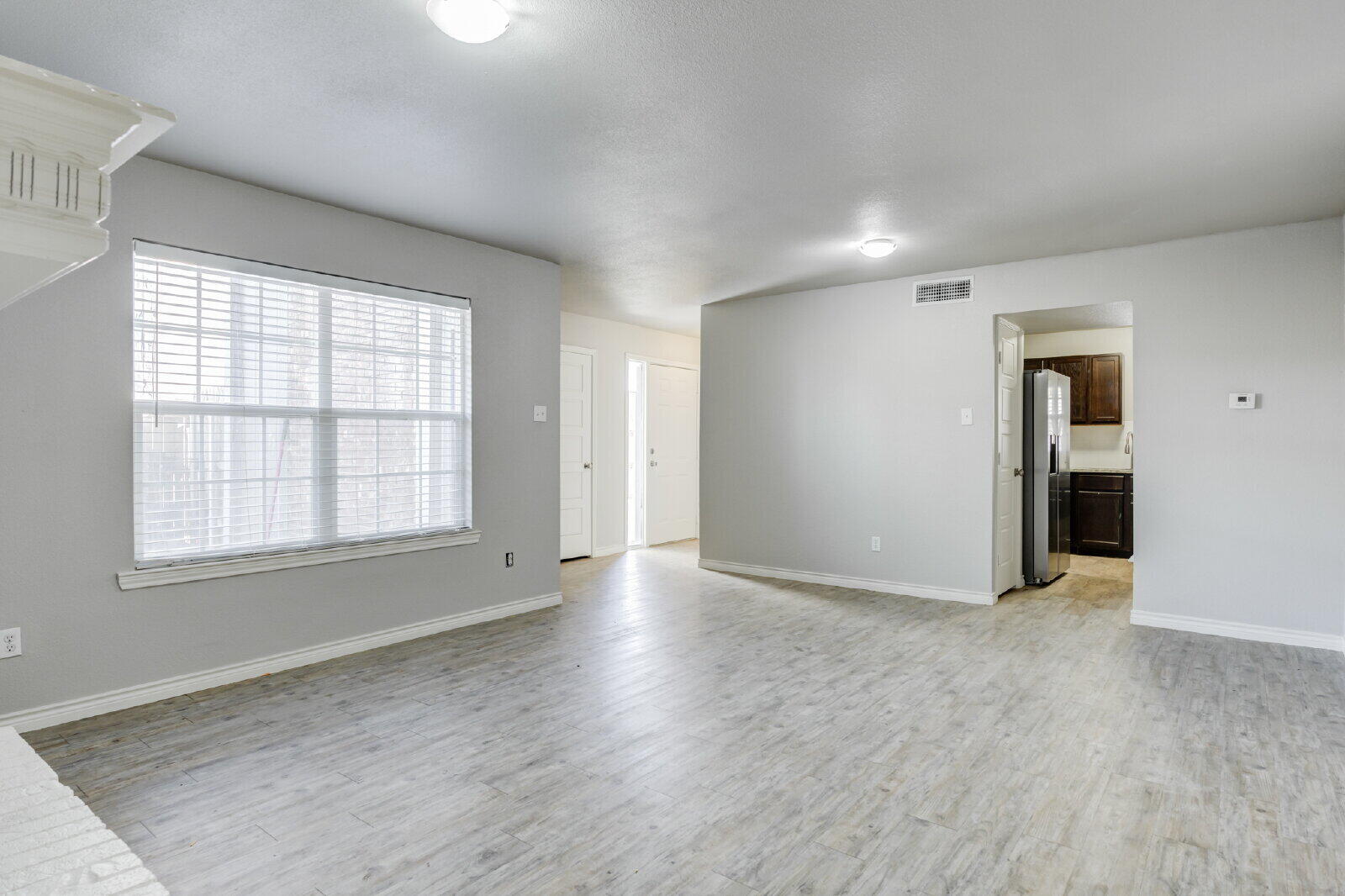 4320 52nd Street, Unit B Lubbock, TX 79413 - Photo 7 of 25 an empty room with wooden floor and windows