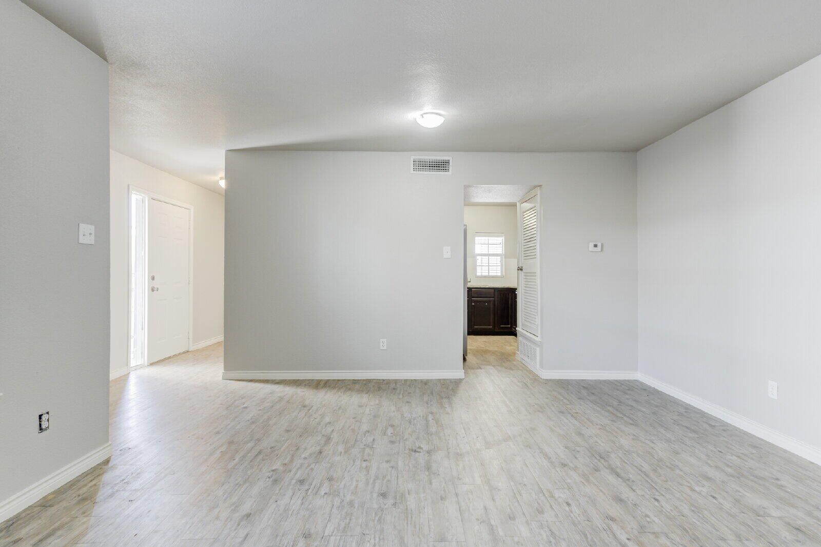 4320 52nd Street, Unit B Lubbock, TX 79413 - Photo 8 of 25 a view of an empty room with wooden floor and cabinets