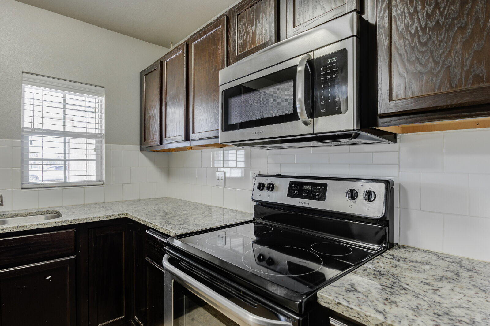 4320 52nd Street, Unit B Lubbock, TX 79413 - Photo 10 of 25 a kitchen with a stove microwave and sink