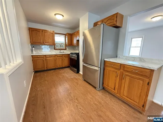a kitchen with granite countertop a refrigerator and a sink