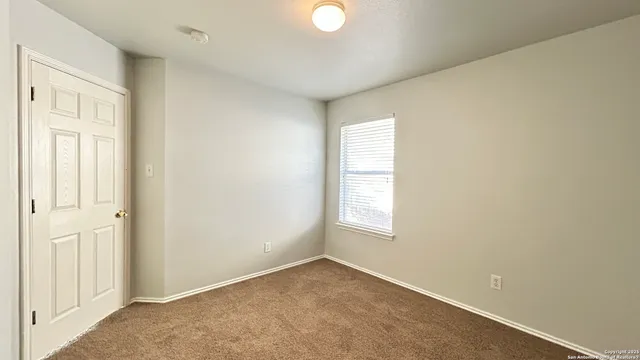 a bathroom with a granite countertop toilet sink and mirror