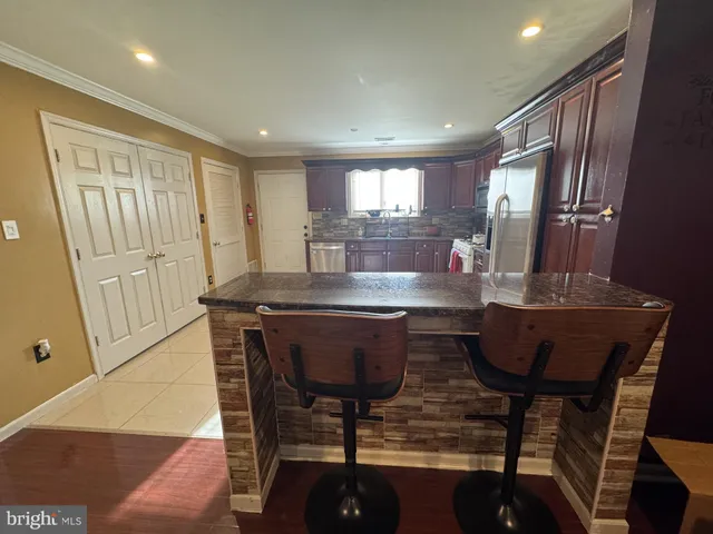 a room with a table chairs and kitchen view