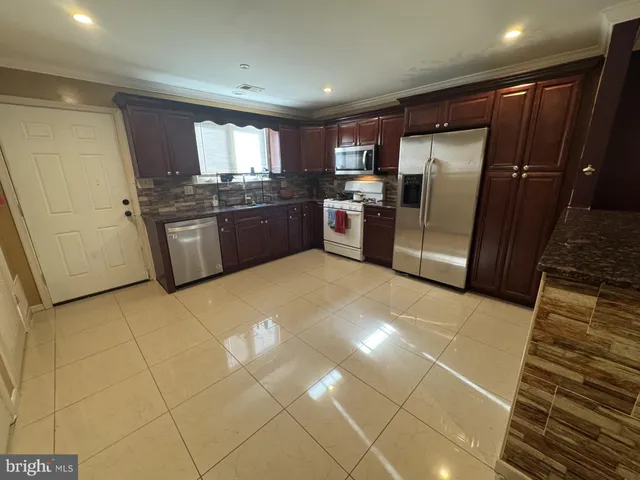 a kitchen with a sink a refrigerator and cabinets
