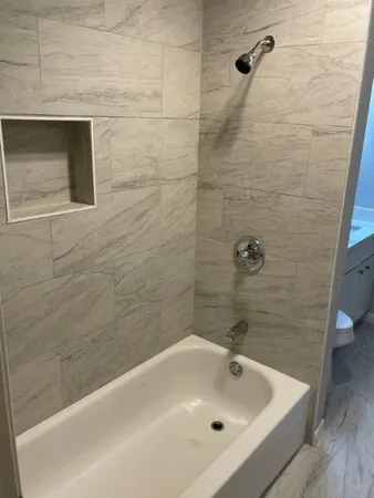 a bathroom with a white bath tub and a shower