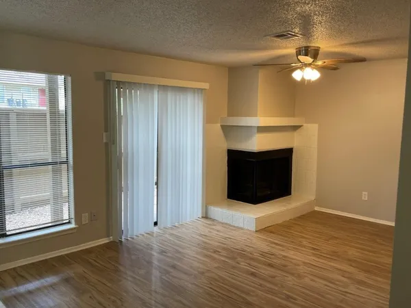 a view of a livingroom with a fireplace and wooden floor