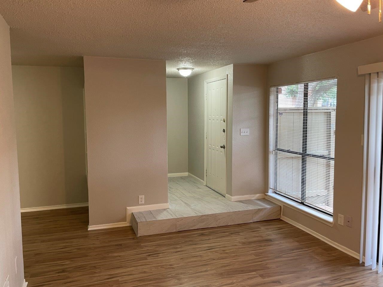 3608 Ocee Street Houston, TX 77063 - Photo 3 of 19 a view of an empty room with wooden floor and a window