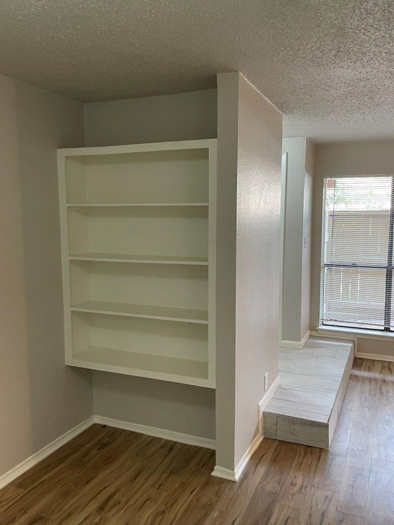 3608 Ocee Street Houston, TX 77063 - Photo 5 of 19 a view of an empty room with wooden floor and a window