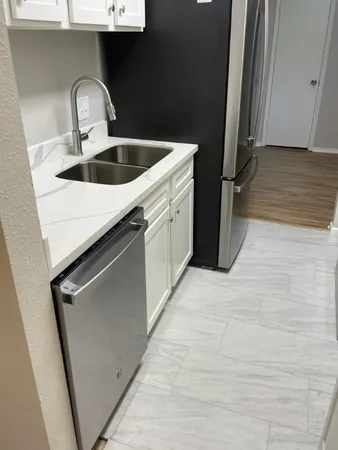 a close view of a sink a refrigerator and window