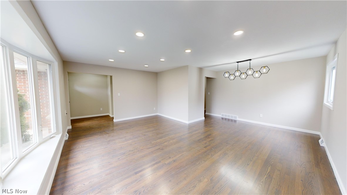 1224 Cordova Road Mayfield Heights, OH 44124 - Photo 4 of 29 Empty room featuring an inviting chandelier, dark hardwood / wood-style flooring, and plenty of natural light