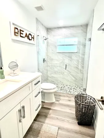 a bathroom with a sink a toilet and shower