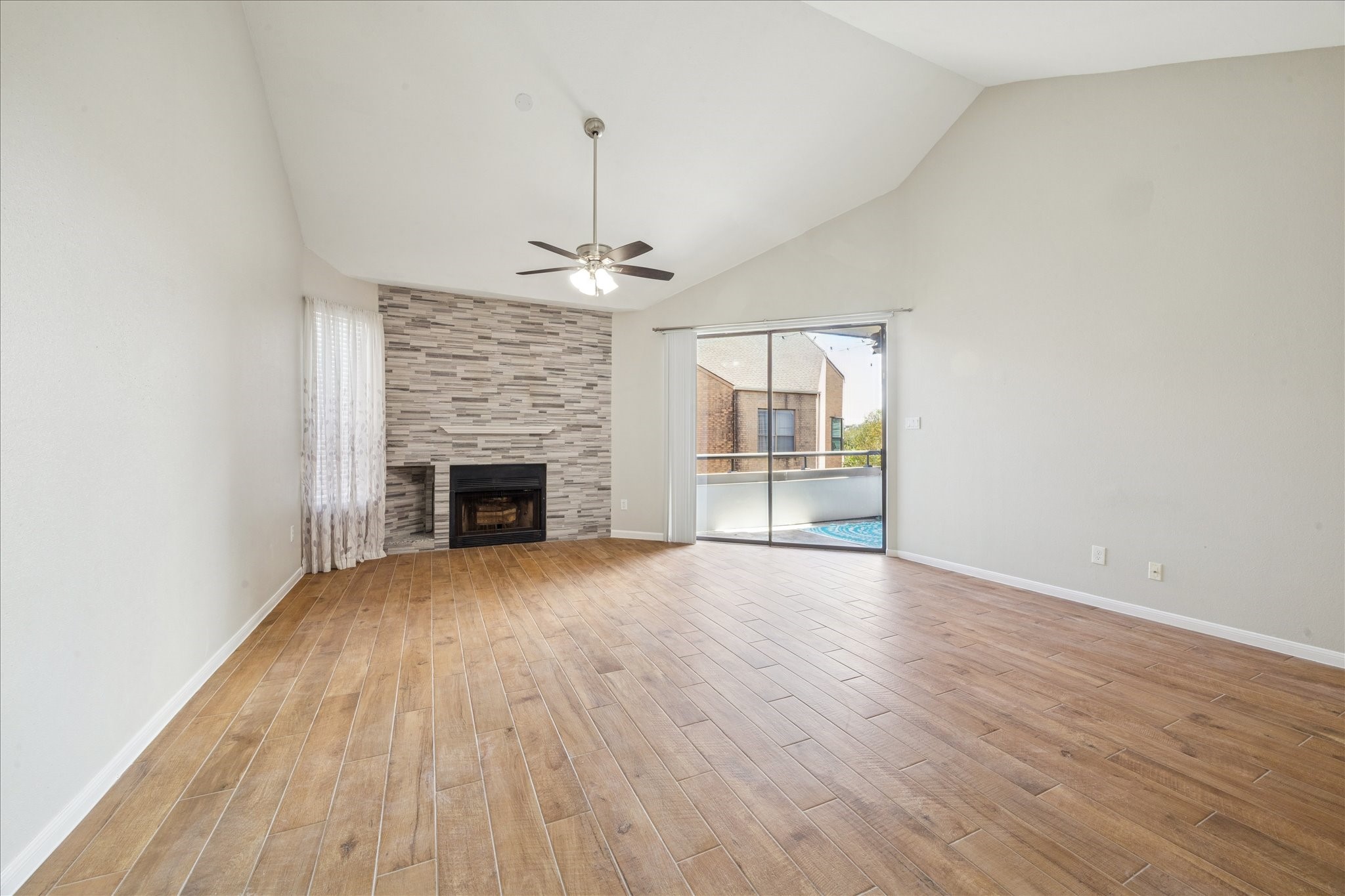 5210 Weslayan Street, Unit 303 Houston, TX 77005 - Photo 4 of 16 a view of an empty room with wooden floor fireplace and a window