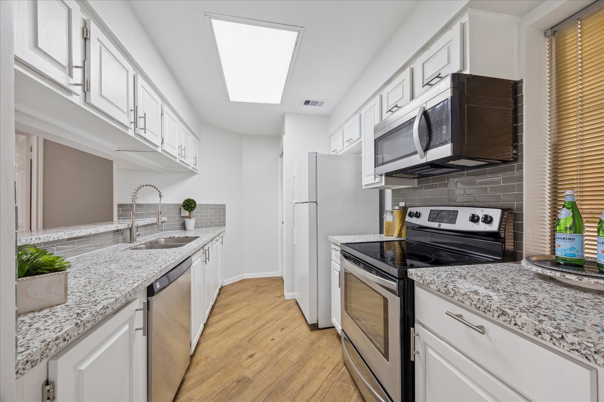 5210 Weslayan Street, Unit 303 Houston, TX 77005 - Photo 6 of 16 a kitchen with stainless steel appliances granite countertop a stove a sink and a microwave
