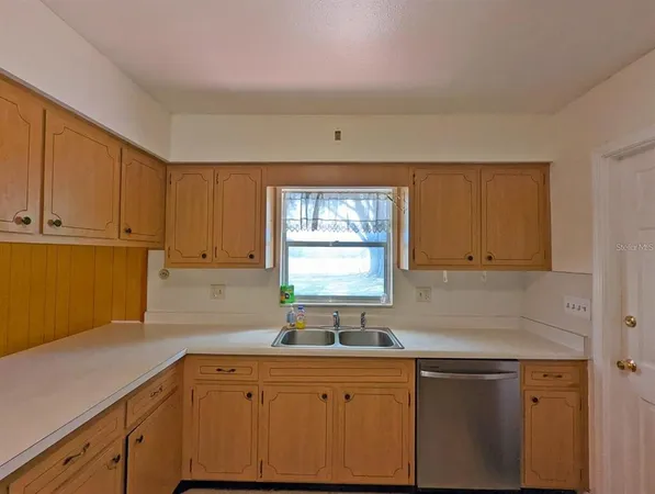 a kitchen with a sink cabinets and window