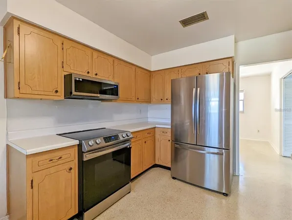 a kitchen with stainless steel appliances granite countertop a refrigerator stove top oven and sink