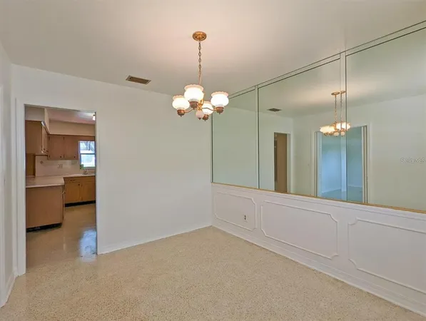 a view of a room with a chandelier fan and bathroom