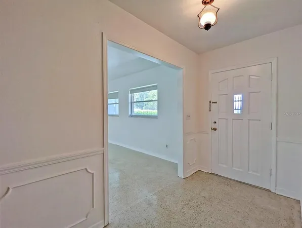 an empty room with chandelier fan