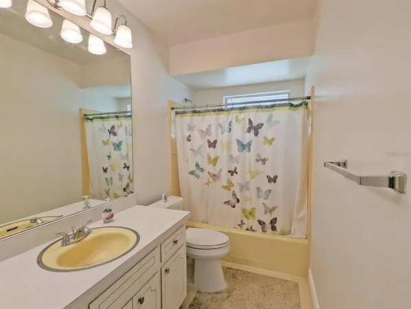 a bathroom with a granite countertop sink toilet a mirror a shower and a bathtub
