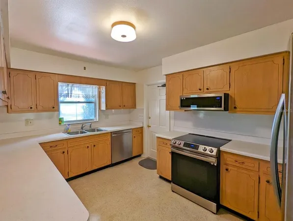 a kitchen with stainless steel appliances granite countertop a stove a sink and a microwave