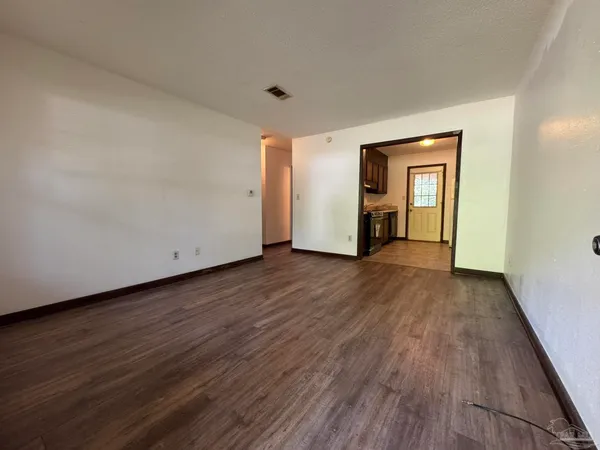 an empty room with wooden floor and closet