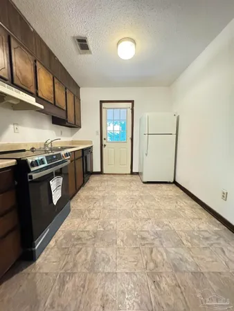 a kitchen with stainless steel appliances granite countertop a stove a sink and a refrigerator