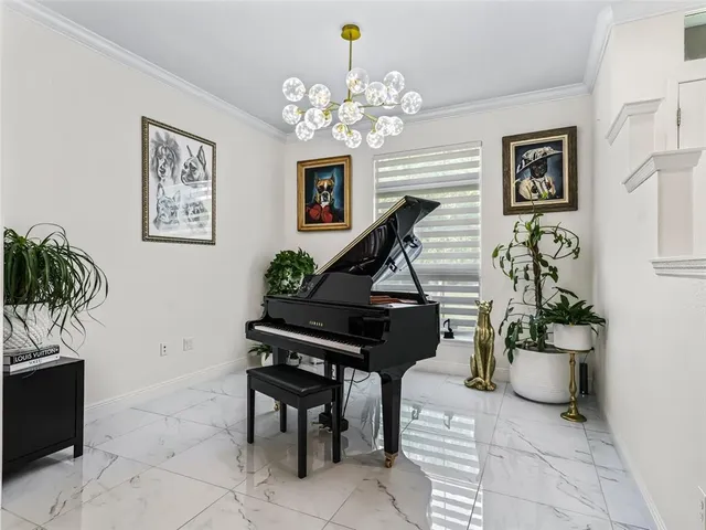 a bedroom with a bed a flat screen tv and a chandelier