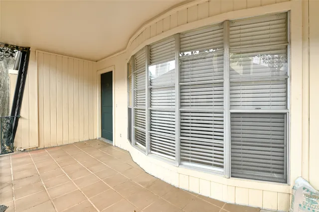 a view of a porch with a door and wooden floor