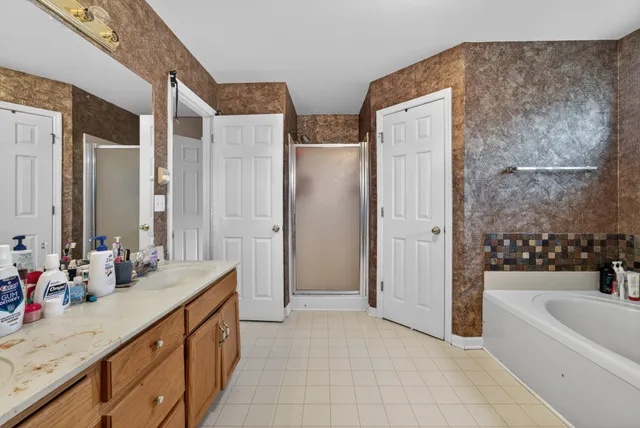a spacious bathroom with double vanity sinks a bathtub and a shower
