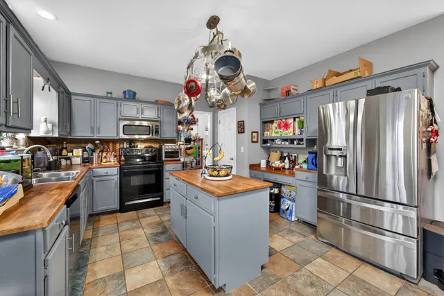 a kitchen with stainless steel appliances granite countertop a refrigerator stove top oven and sink