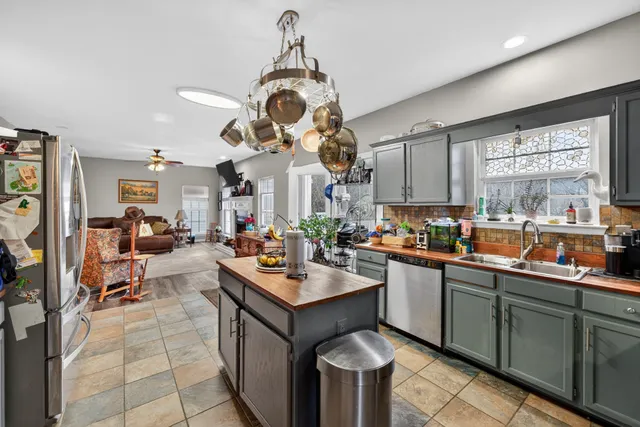 a kitchen with a sink a counter space appliances and cabinets
