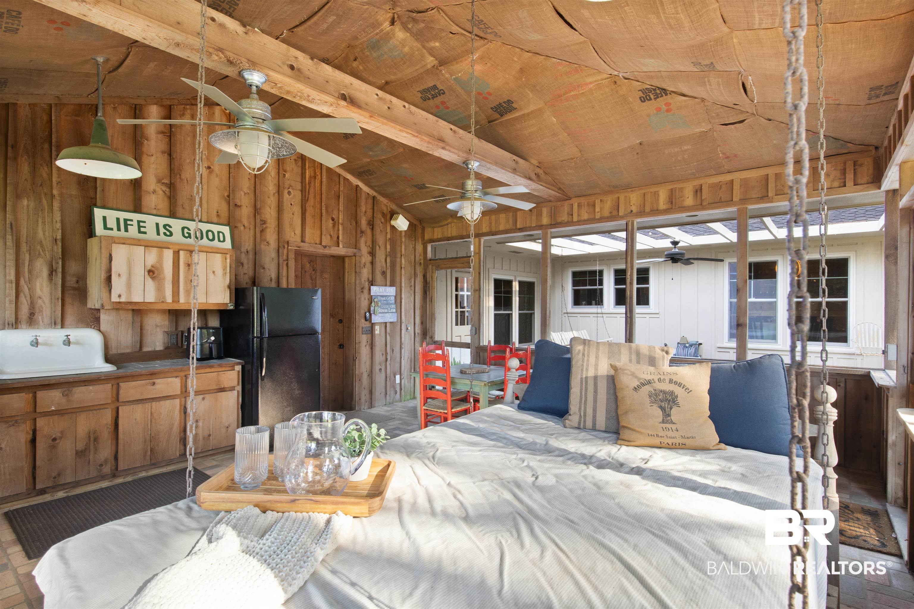 15100 Vasko Road Silverhill, AL 36576 - Photo 4 of 51 Interior space with lofted ceiling with beams, wood ceiling, wooden walls, and black fridge and dining table