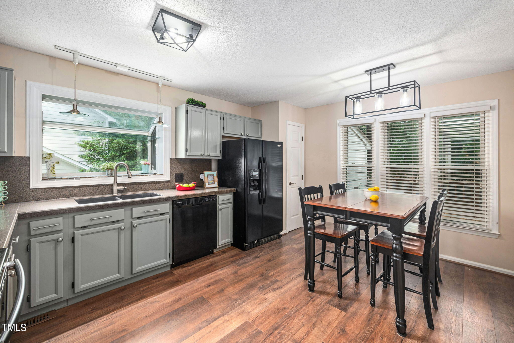 4400 Emmit Drive Raleigh, NC 27604 - Photo 8 of 38 a kitchen with stainless steel appliances granite countertop a dining table chairs refrigerator sink and cabinets