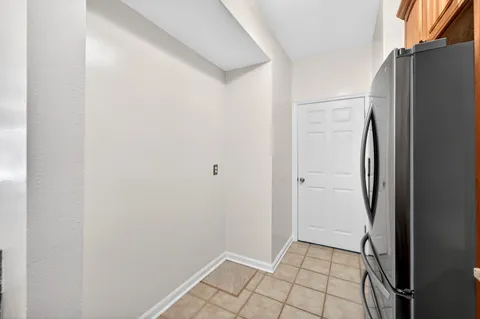 a view of a refrigerator in kitchen and an empty room