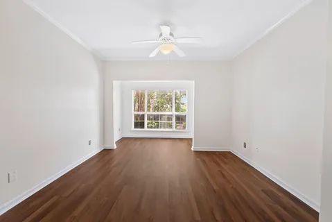 an empty room with wooden floor and windows