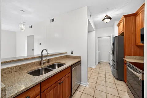 a kitchen with stainless steel appliances granite countertop a sink stove and refrigerator