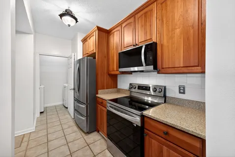 a kitchen with stainless steel appliances granite countertop a stove a refrigerator and a microwave