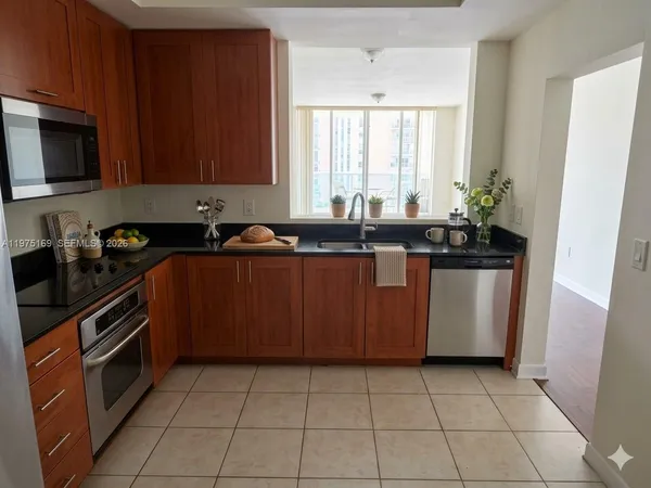a kitchen with stainless steel appliances a sink a stove a microwave and cabinets