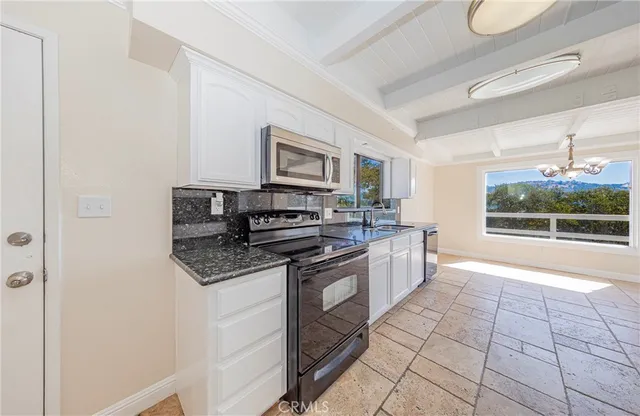 an empty room with windows and chandelier fan