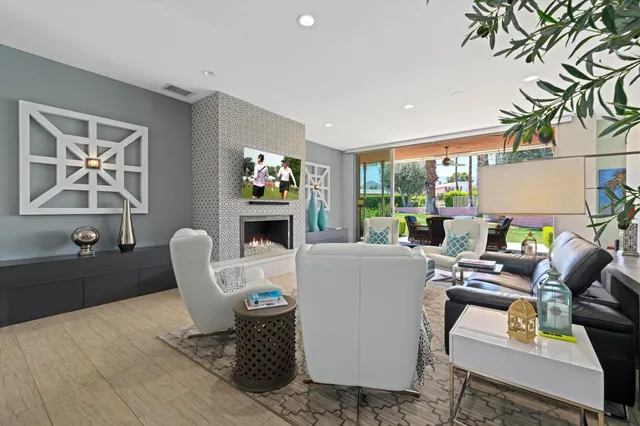 a living room with furniture a flat screen tv and a wall painting