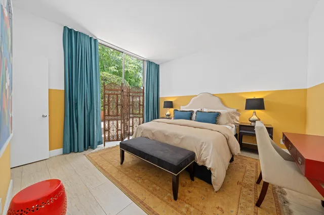 a bedroom with a bed and dresser with mirror