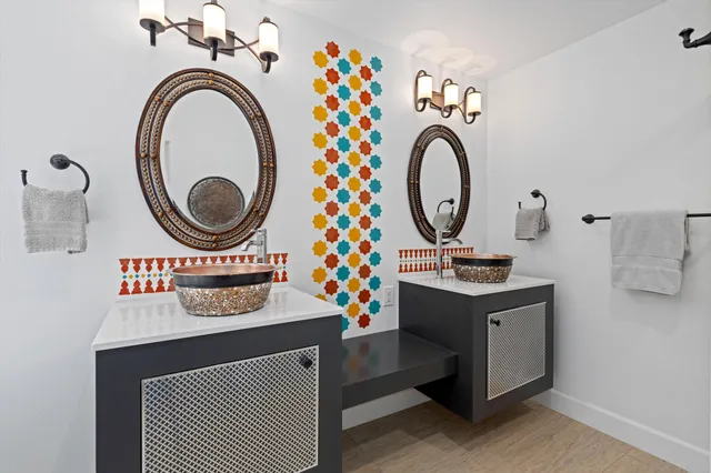 a bedroom with a bed painting on wall and a large window